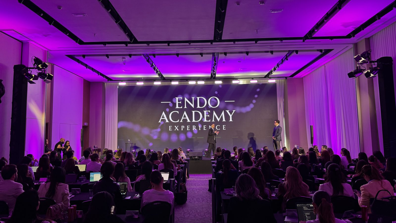 Evento Endo Academy com painel LED e processador de vídeo profissional no palco