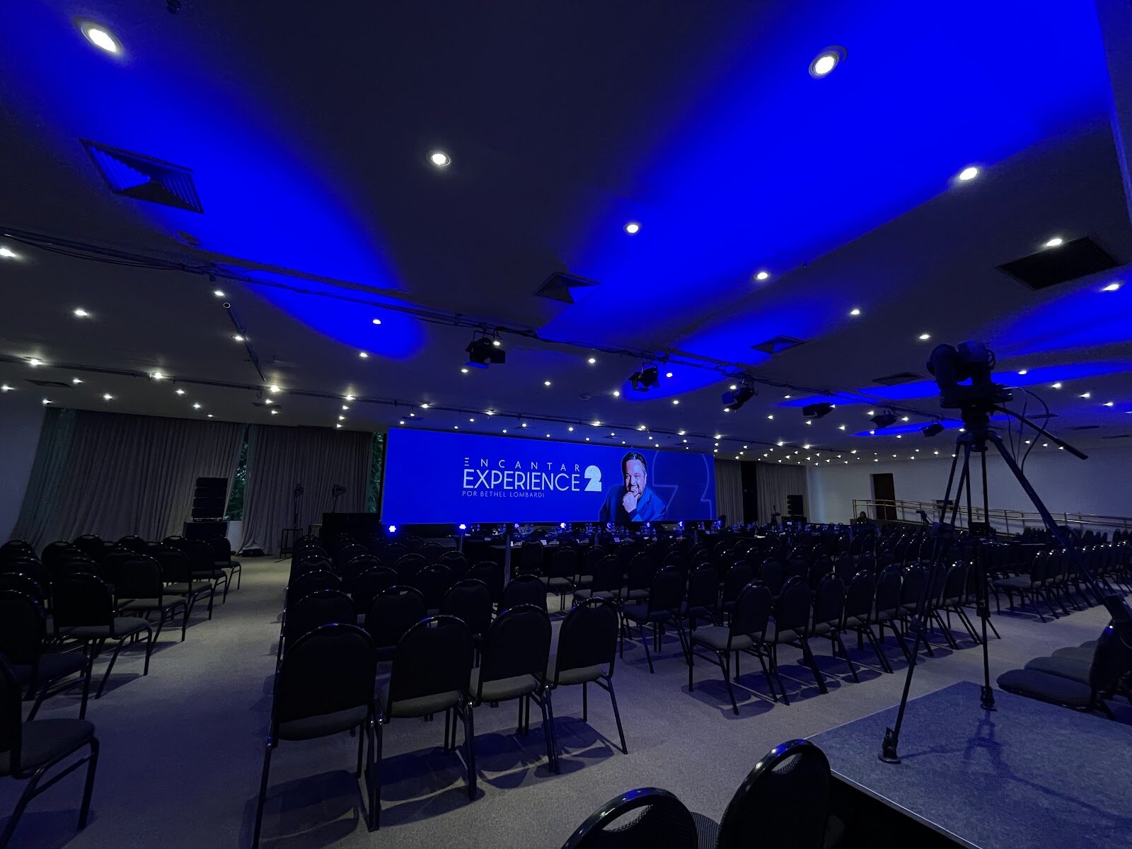 Câmera de transmissão ao vivo diante de telão de LED em evento corporativo