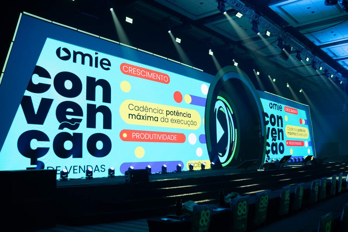 Palco de convenção de vendas com painéis de LED em tela cheia e iluminação cênica